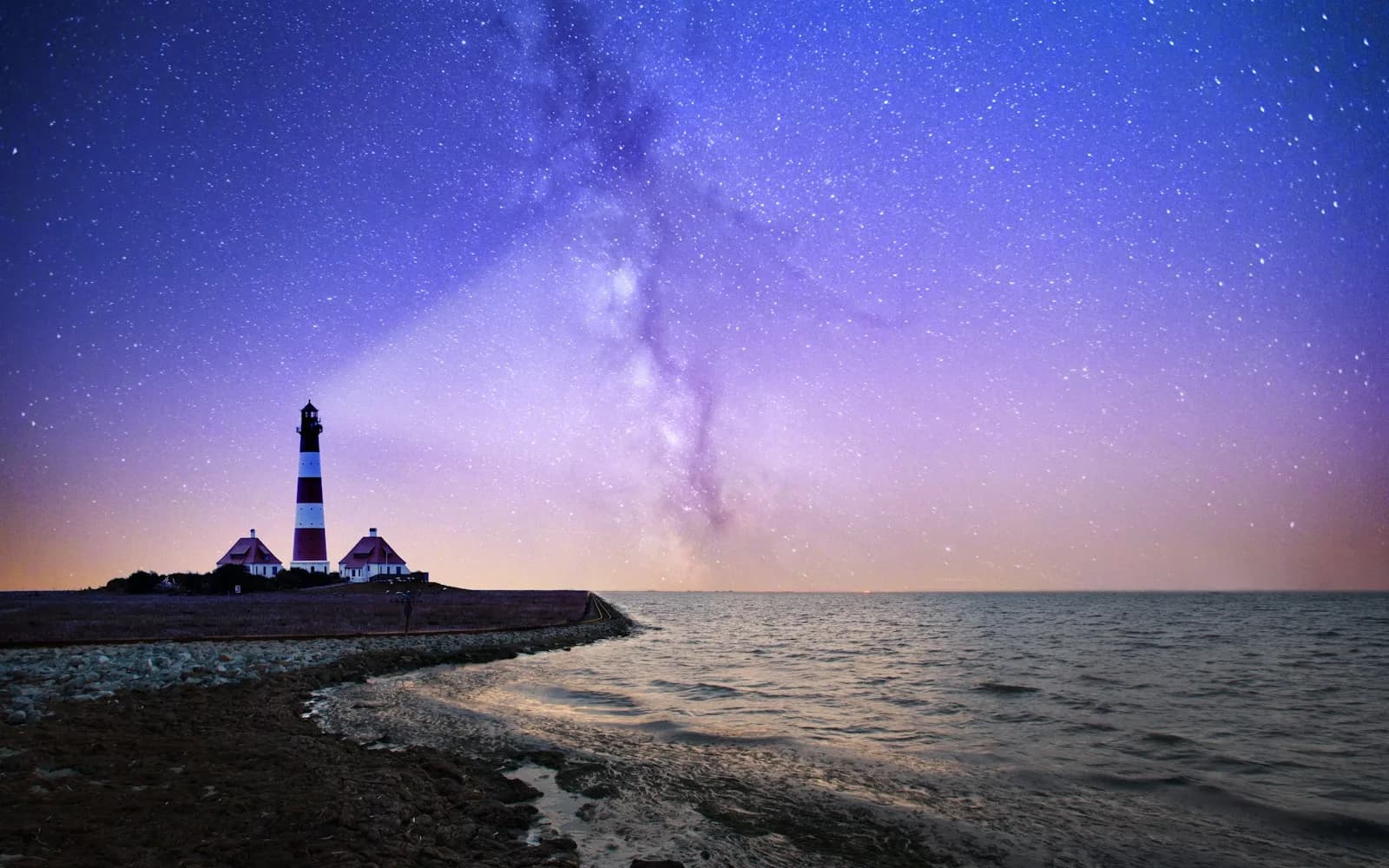 A lighthouse shining its beam over the water at night