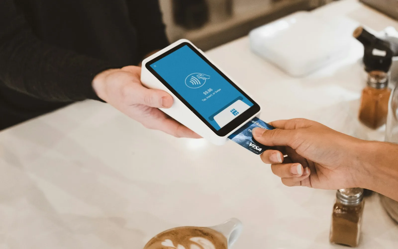 A person inserting a credit card into a payment terminal